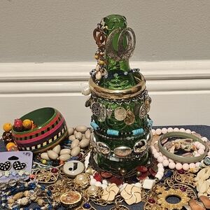 Colorful Jewelry Collection with Green Glass Bottle